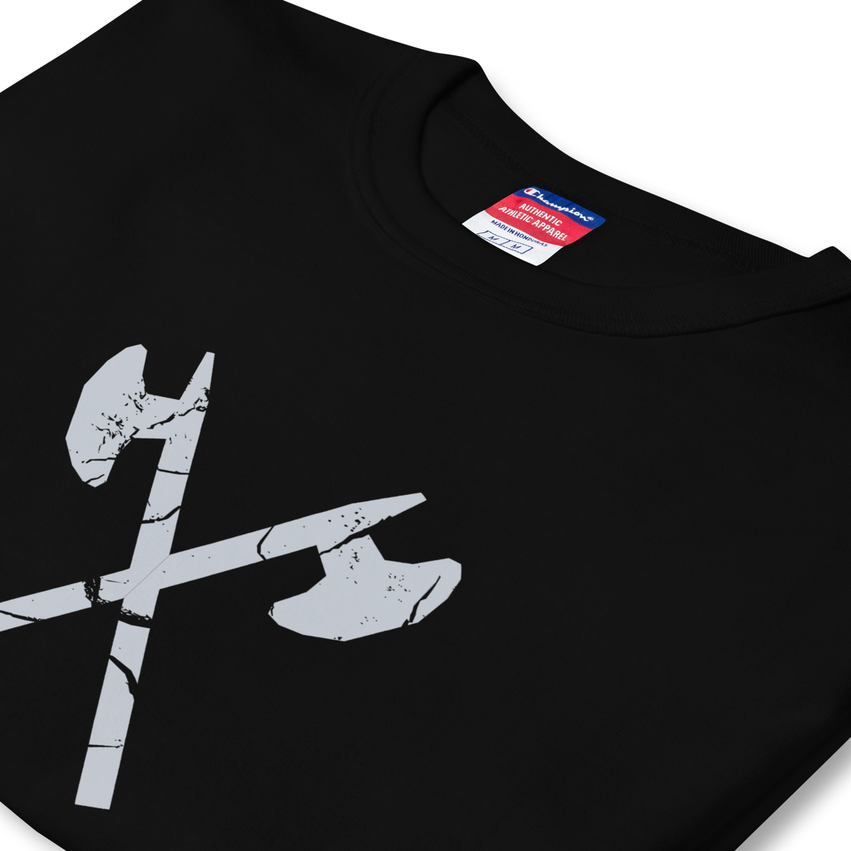 Folded side profile of black heavyweight, 100% cotton luxury Champion© t-shirt featuring aged crossed axes emblem and text "EST. 1984" indicating the year the faction was first introduced to the brick universe. Item is a BRKDrip Heritage Collection luxury shirt with a vintage castle building block aesthetic.
