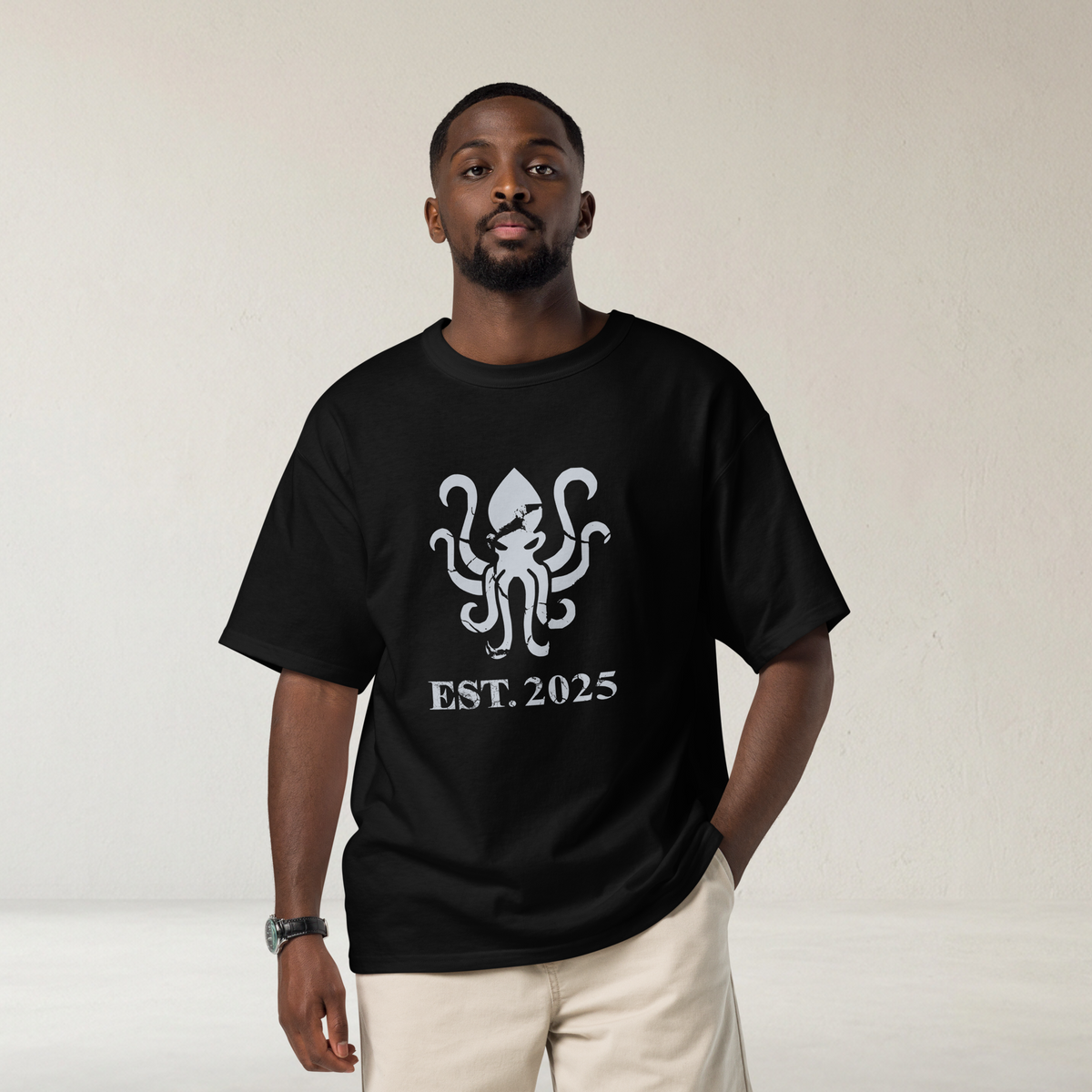 Fashionable male modeling wearing a black heavyweight, 100% cotton luxury Champion© t-shirt featuring aged terrifying kraken sea monster emblem and text "EST. 2020" indicating the year the faction was first introduced to the brick universe. Item is a BRKDrip Heritage Collection luxury shirt with a vintage castle building block aesthetic.