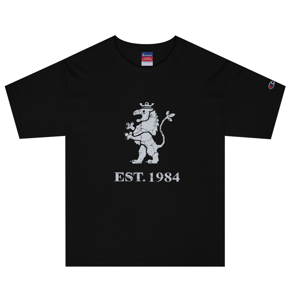 Black heavyweight, 100% cotton luxury Champion© t-shirt featuring aged lion emblem and text "EST. 1984" indicating the year the faction was first introduced to the brick universe. Item is a BRKDrip Heritage Collection luxury shirt with a vintage castle building block aesthetic.